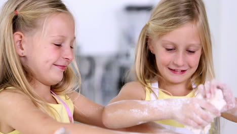 twin sisters making dough for cake