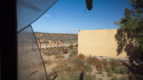 A motion time-lapse on an abandoned farm looking through a broken window