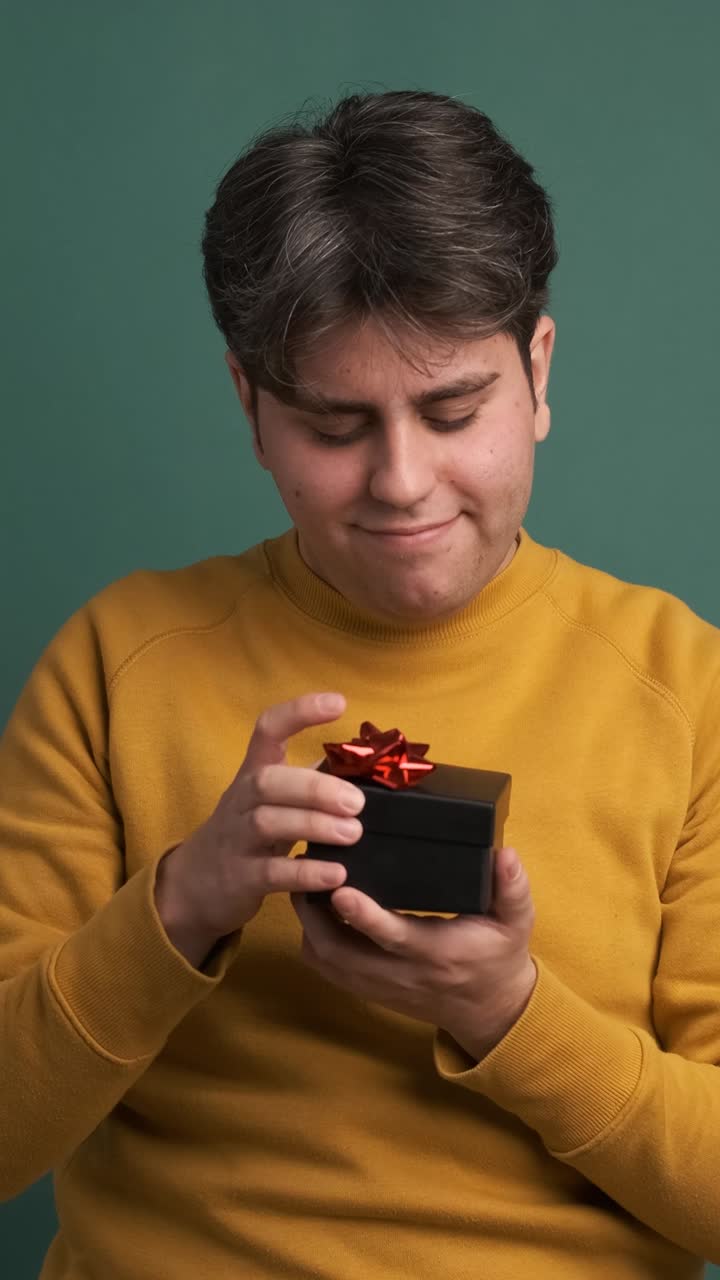 Smiling ethnic young man receiving gift box