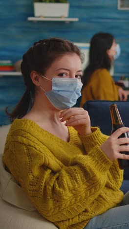 vertical video: pretty lady taking off protection face mask looking at camera