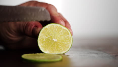 professional chef cutting lime on wood chopping block