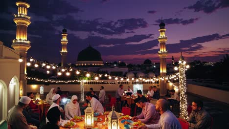 several muslim families are gathering on a rooftop at dusk, enjoying a traditional iftar dinner during the holy month of ramadan, with a mosque in the background