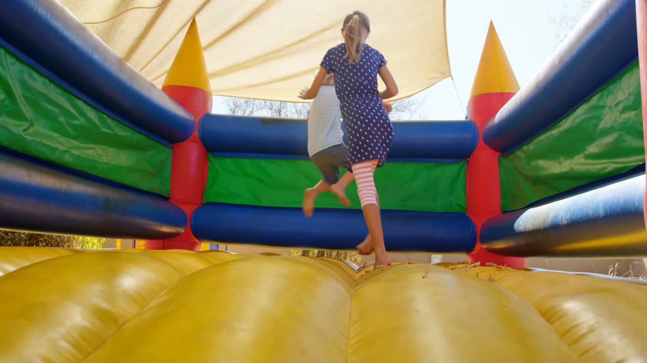 niños jugando en el castillo saltador 4k