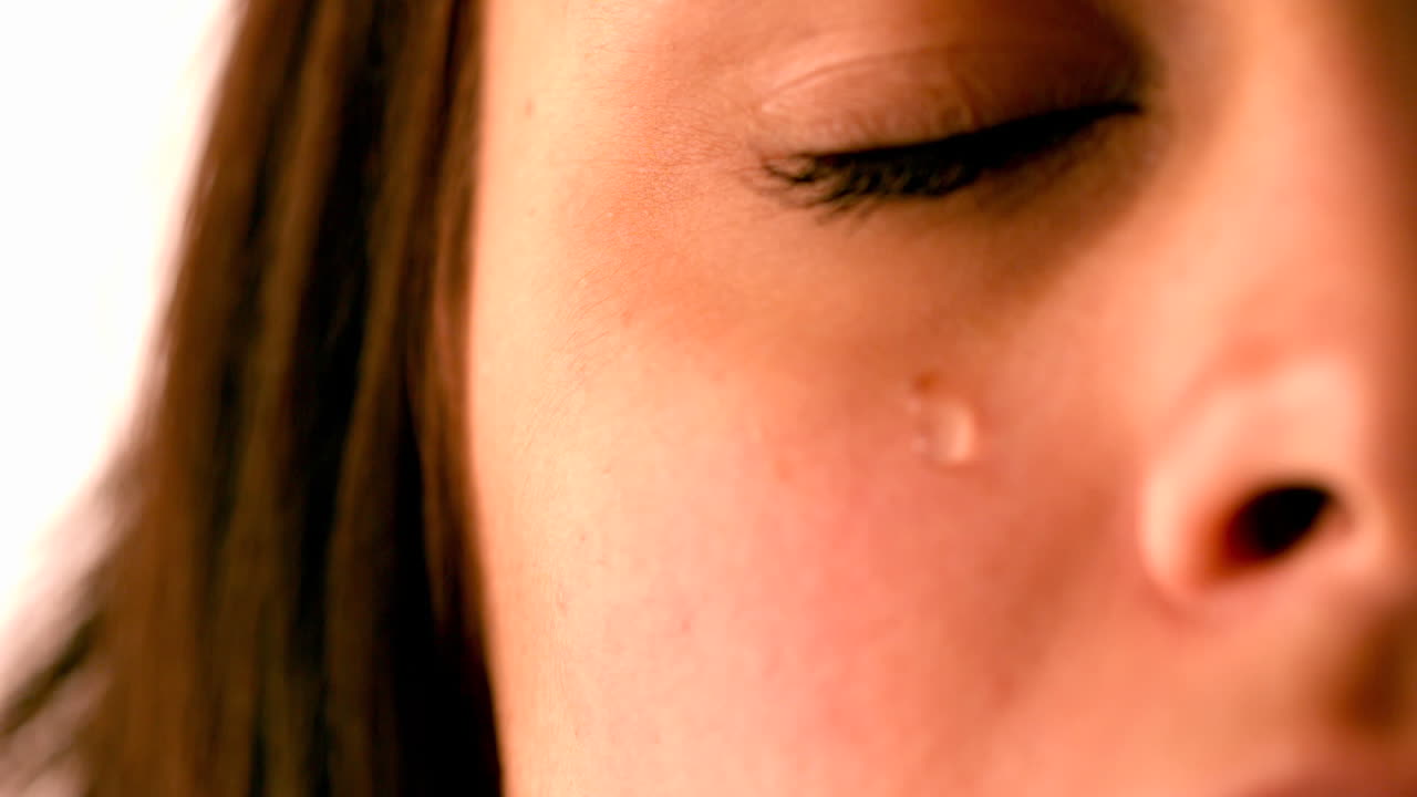 Upset brunette with tear rolling down cheek
