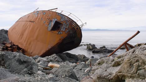 Rostiges-Schiffswrack,-Das-Am-Felsigen-Strand-Aufgegeben-Wurde