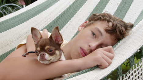 boy relaxing in a hammock with his dog