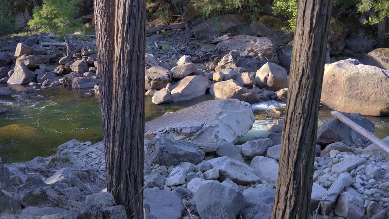 Peaceful river scene in Yosemite where giant boulders fill the riverbed as water flows gracefully around them