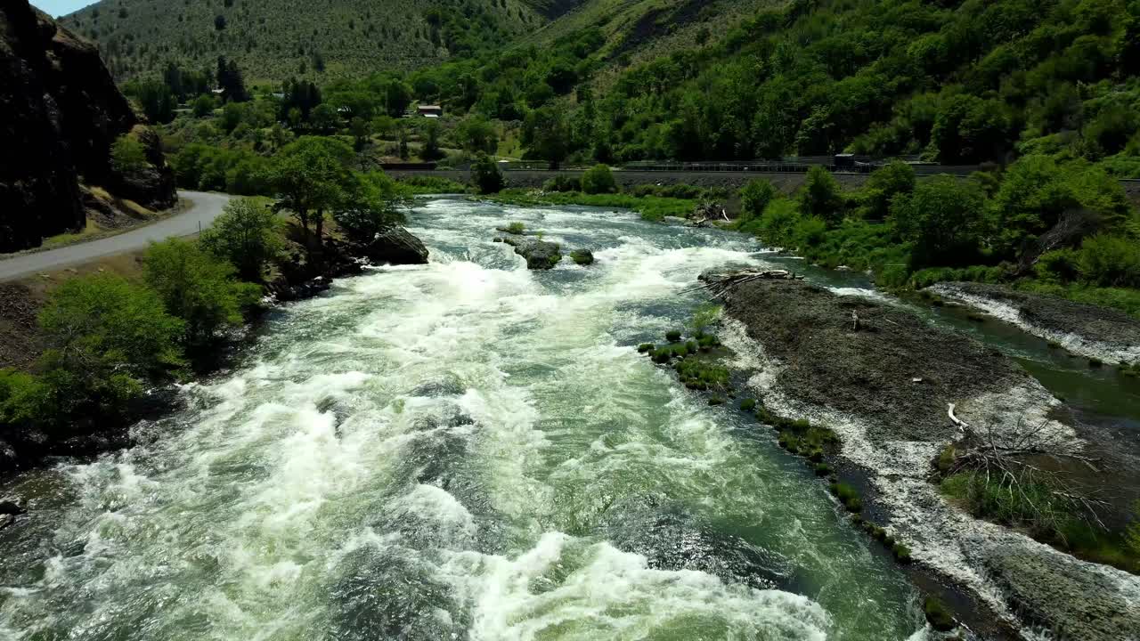 US, Oregon, Maupin, Baxter Rapids, 2025-05-08 - Drone view over the Deschutes River in Spring with a railroad line and green trees in north central Oregon