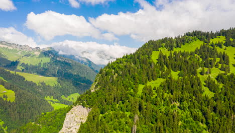 Atemberaubender-Hyper-Zeitraffer-Aus-Der-Luft-Mit-Grünen-Bergen-Und-Weißen-Wolken,-Die-Durch-Einen-Klaren,-Blauen-Himmel-Rollen