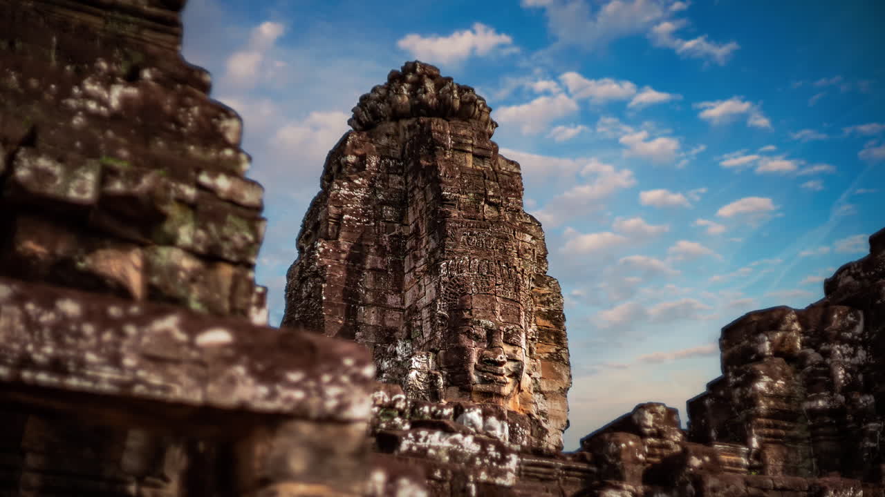 Cinemagraph time lapse of smiling stone faces of Bayon Temple. Angkor Wat, Cambodia. Moving clouds sky.
