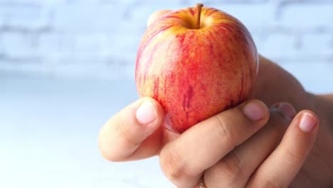 persona que sostiene una manzana roja