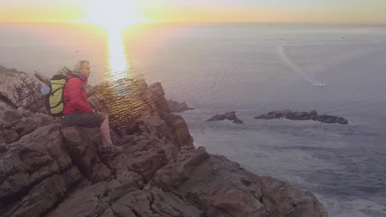 feliz caucásica mujer mayor caminando por la costa durante el atardecer