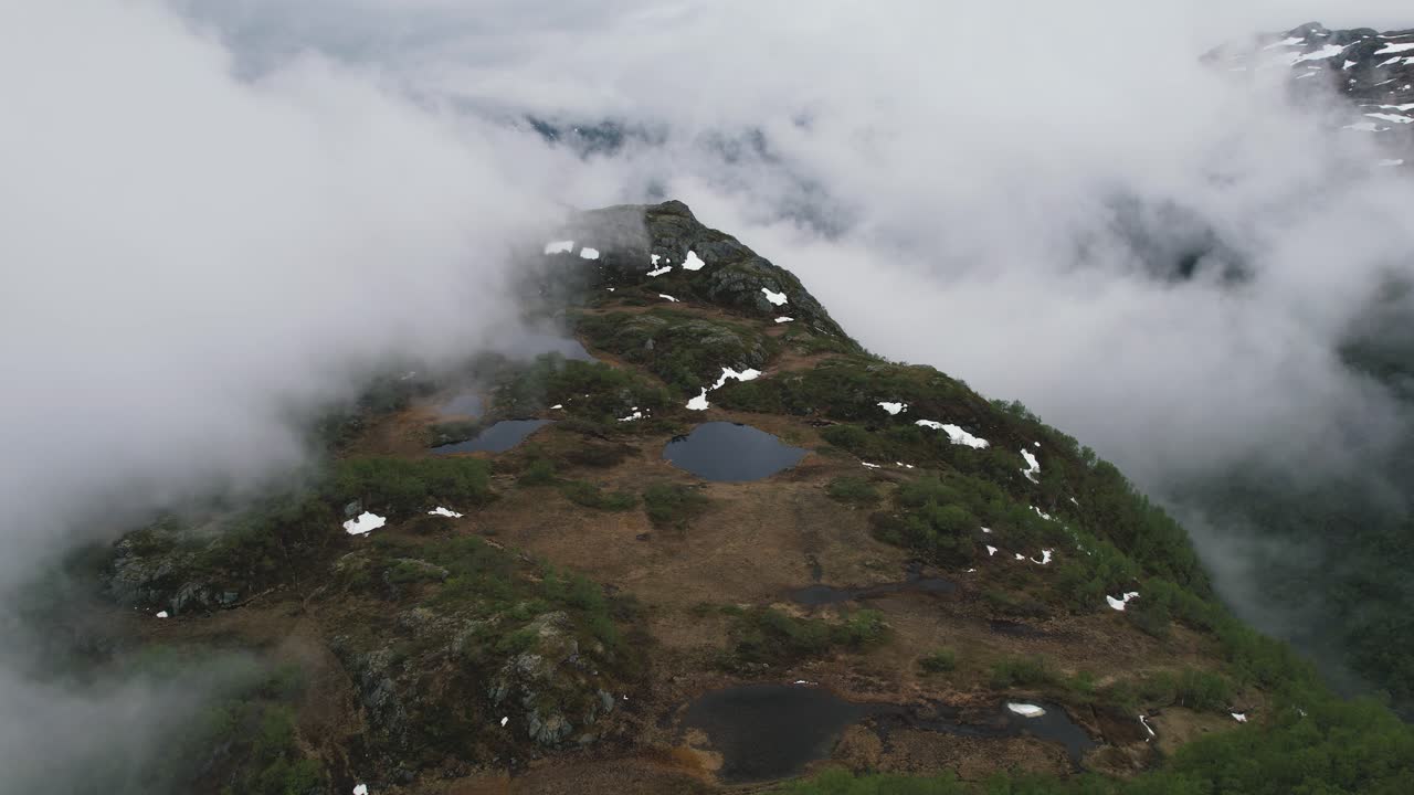 노르웨이, 에이드피요르드, 하르당에르비다 국립공원에 있는 작은 호수가 있는 안개 낀 산 위로 공중 비행