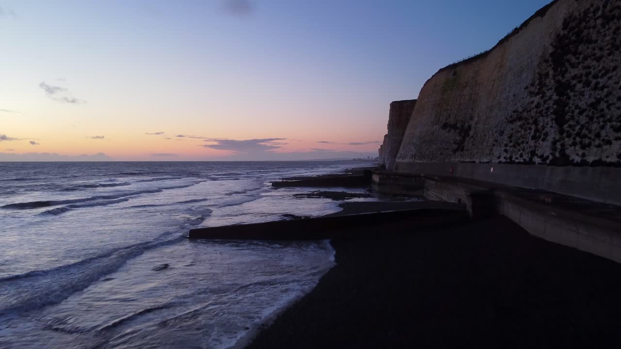 drone disparó costa de brighton y playa con acantilados al atardecer en inglaterra