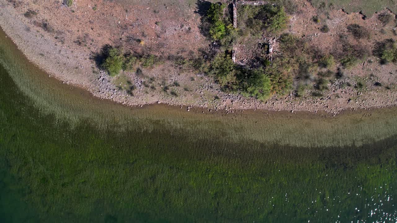 agua verde del lago de superficie tranquila en la orilla vista desde arriba en las montañas cerca de las ruinas