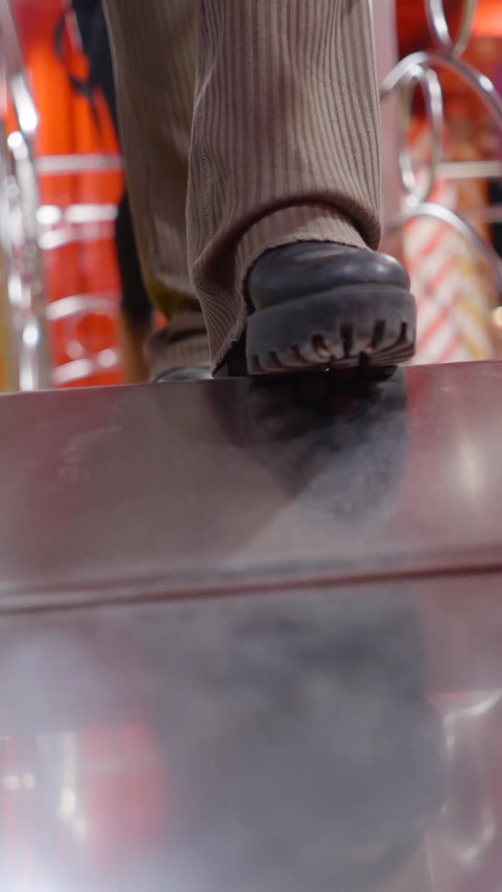 Close-up of Feet and Footwear on a Metal Surface