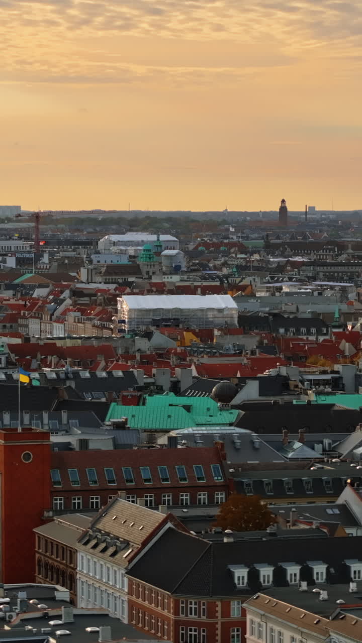 Letecký dronový pohled na palác Christiansborg na ostrůvku Slotsholmen v centru Kodaně, Dánsko při západu slunce. Vertikální