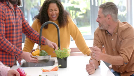 Happy-diverse-male-and-female-friends-preparing-food-together-in-kitchen