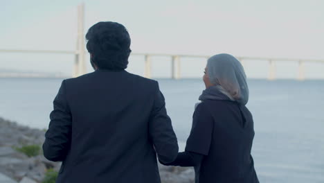 Rückansicht-Eines-Glücklichen-Arabischen-Paares,-Das-Den-Fluss-Entlang-Läuft