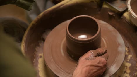 primer plano de manos masculinas haciendo un cuenco de arcilla en una rueda de alfarero. artesanía y producción de artículos de té exclusivos hechos de arcilla