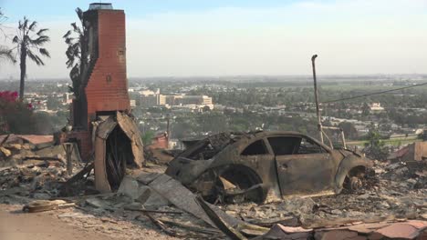 burned cars smolder beside a hillside house following the 2017 thomas fire in ventura county california