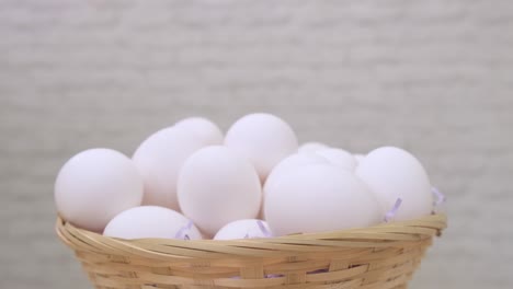 white chicken eggs rotate in basket on light background