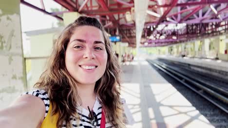 young female traveler waiting at a train station platform