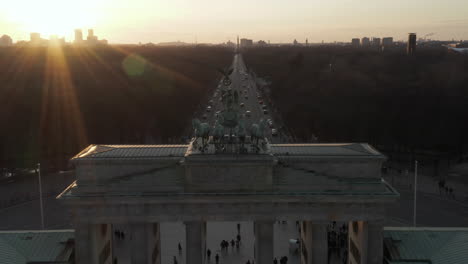 Antena:-Acercándose-Lentamente-A-La-Puerta-De-Brandenburgo-Y-Al-Tiergarten-Bajo-La-Hermosa-Luz-Del-Sol-Del-Atardecer-Con-Una-Vista-Cercana-De-La-Estatua-Verde-Quadriga-En-Berlín,-Alemania