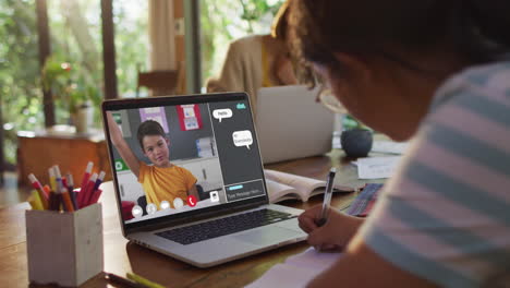 composite video of girl using laptop for online lesson at home, with boy raising hand on screen