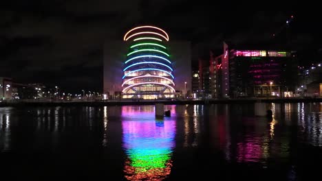 Toma-Fija-Del-Centro-De-Convenciones-De-Dublín-Con-Vehículos-Y-Nubes-Que-Pasan-Y-La-Noche