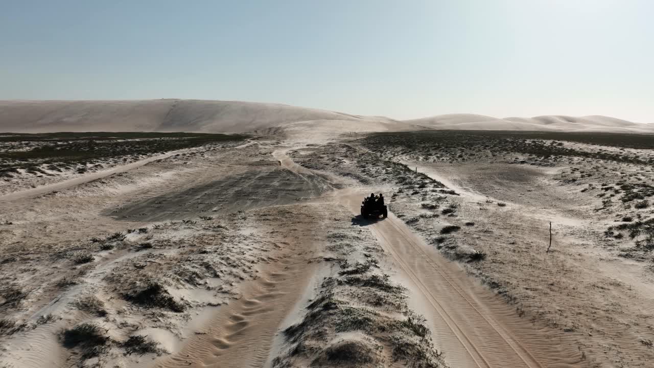 Ripresa aerea in movimento di un quad che guida su dune sabbiose nel nord-est del Brasile - Desertificazione durante una giornata di sole in un'area arida