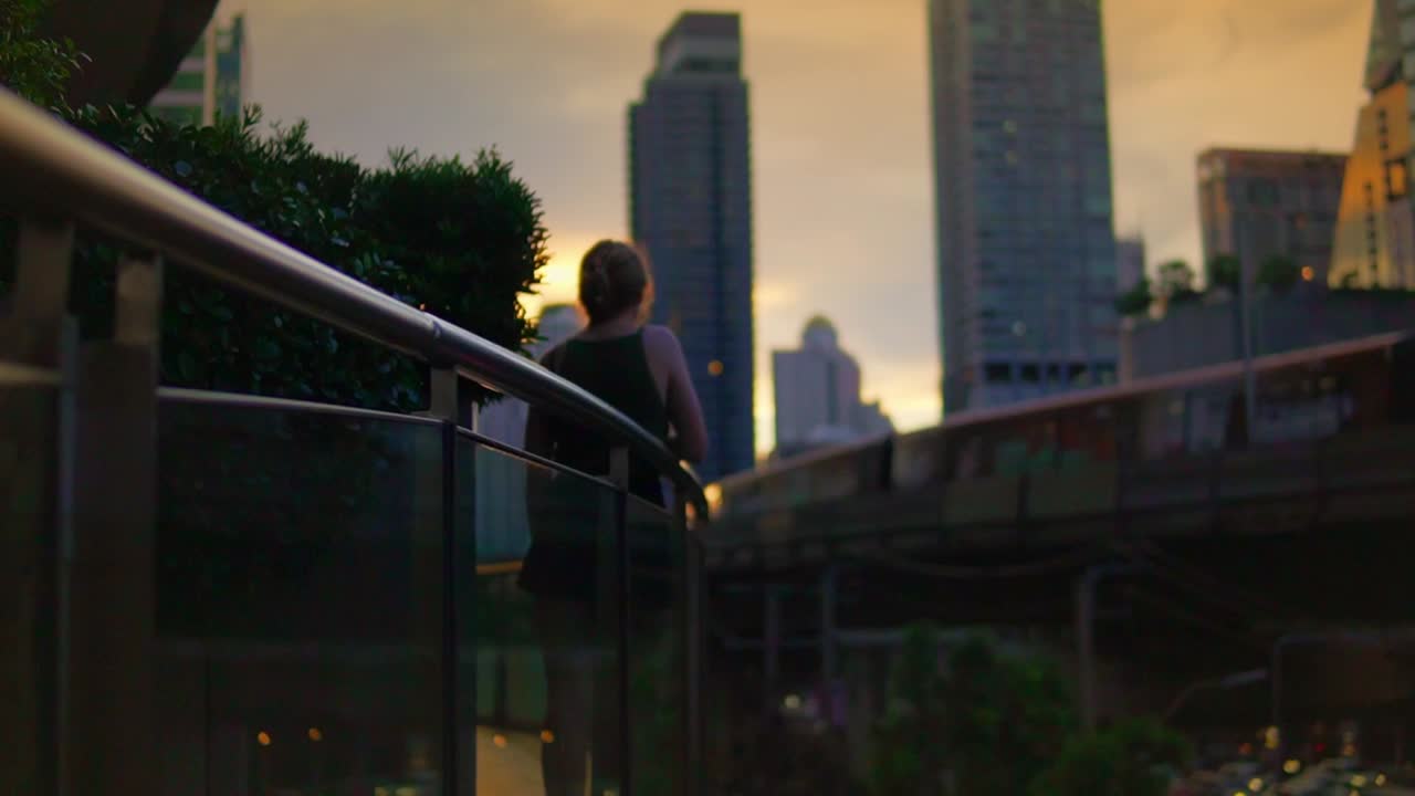 mujer joven viendo el tren bts sky pasar por el moderno distrito central de negocios de bangkok tailandia