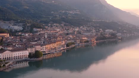 Drohnenblick-Auf-Den-Iseosee-Bei-Sonnenaufgang,-Links-Die-Stadt-Lovere,-Die-Entlang-Des-Sees-Verläuft,-Bergamo,-Italien