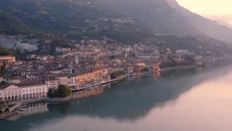 vista de drones del lago iseo al amanecer, a la izquierda la ciudad de lovere que corre a lo largo del lago, bergamo italia