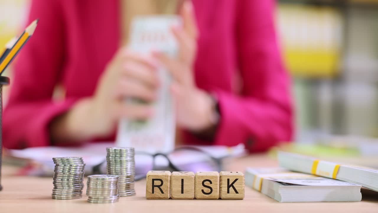 İş kadını nakit sayarken tahta küpler risk kelimesini heceliyor