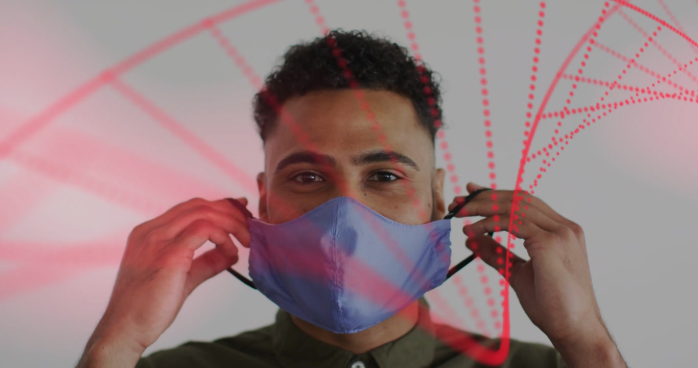 Man smiling, raising blue cloth mask, securing black ear loops for health, red particles sweeping