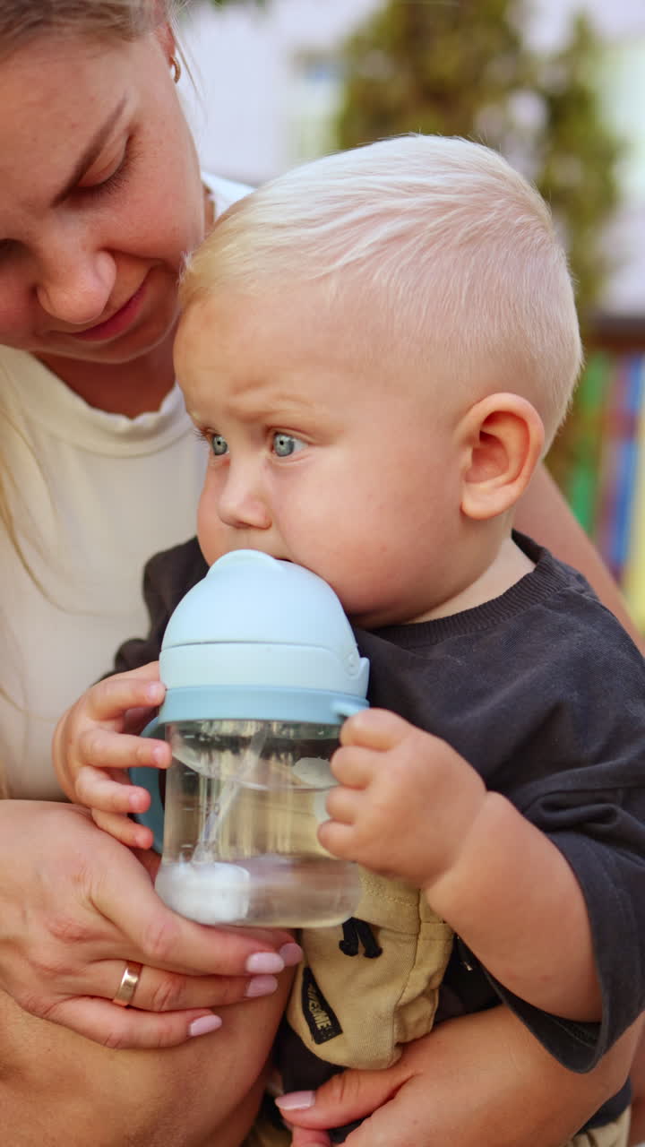 Un adorabile bambino piccolo si gode felicemente una bevanda rinfrescante in un ambiente allegro e giocoso
