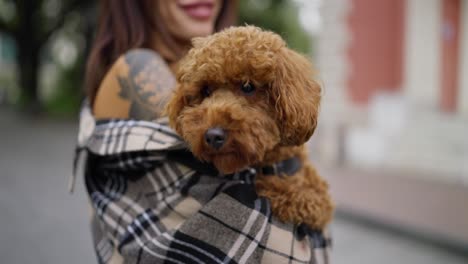 una mujer con un adorable caniche marrón.