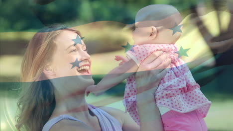 composite video of waving honduras flag over caucasian mother playing with her daughter in the park