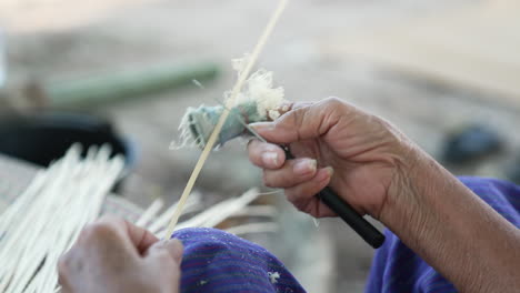 Cámara-Lenta-Raspando-Palos-De-Bambú-Con-Un-Cuchillo,-Hábil-Tejido-De-Bambú,-Cerrar