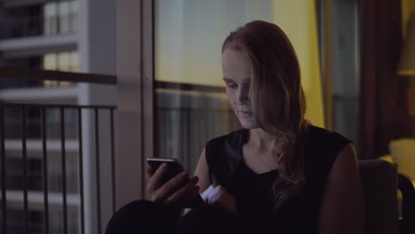 woman surfing internet on cell being bored at home in the evening