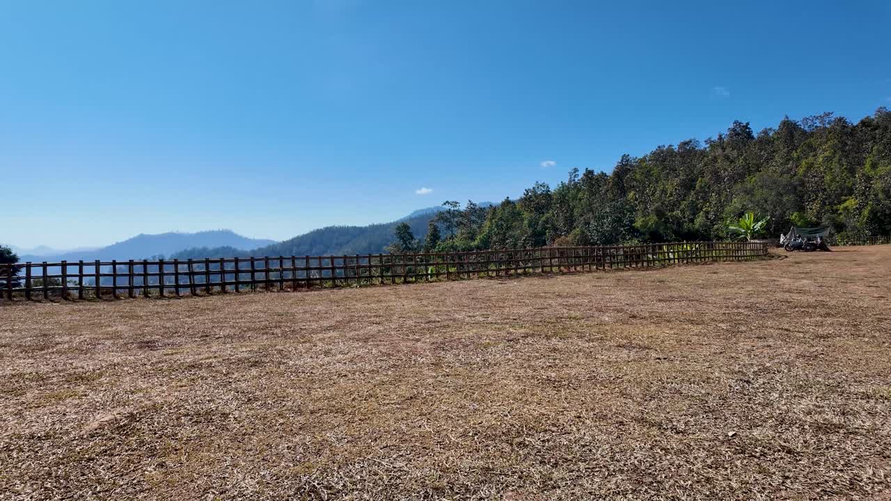 Pemandangan pedesaan dengan perkebunan pisang dan lapangan terbuka dekat Titik Pandang Yun Lai di Distrik Pai, Provinsi Mae Hong Son, Thailand Utara, dengan pegunungan berhutan di bawah langit biru cerah