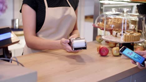 mujer pagando en una cafetería