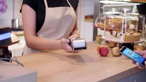 woman paying at coffee shop