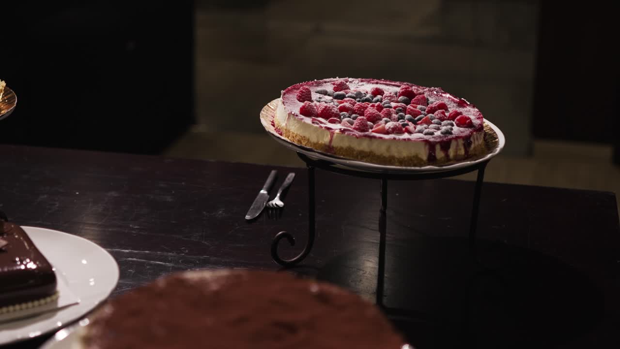 Cheesecake guarnita con lamponi e mirtilli su un tavolo di dolci nuziali