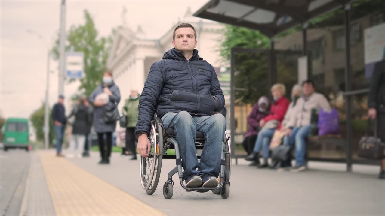 persona con discapacidad física que espera un transporte urbano con una rampa accesible