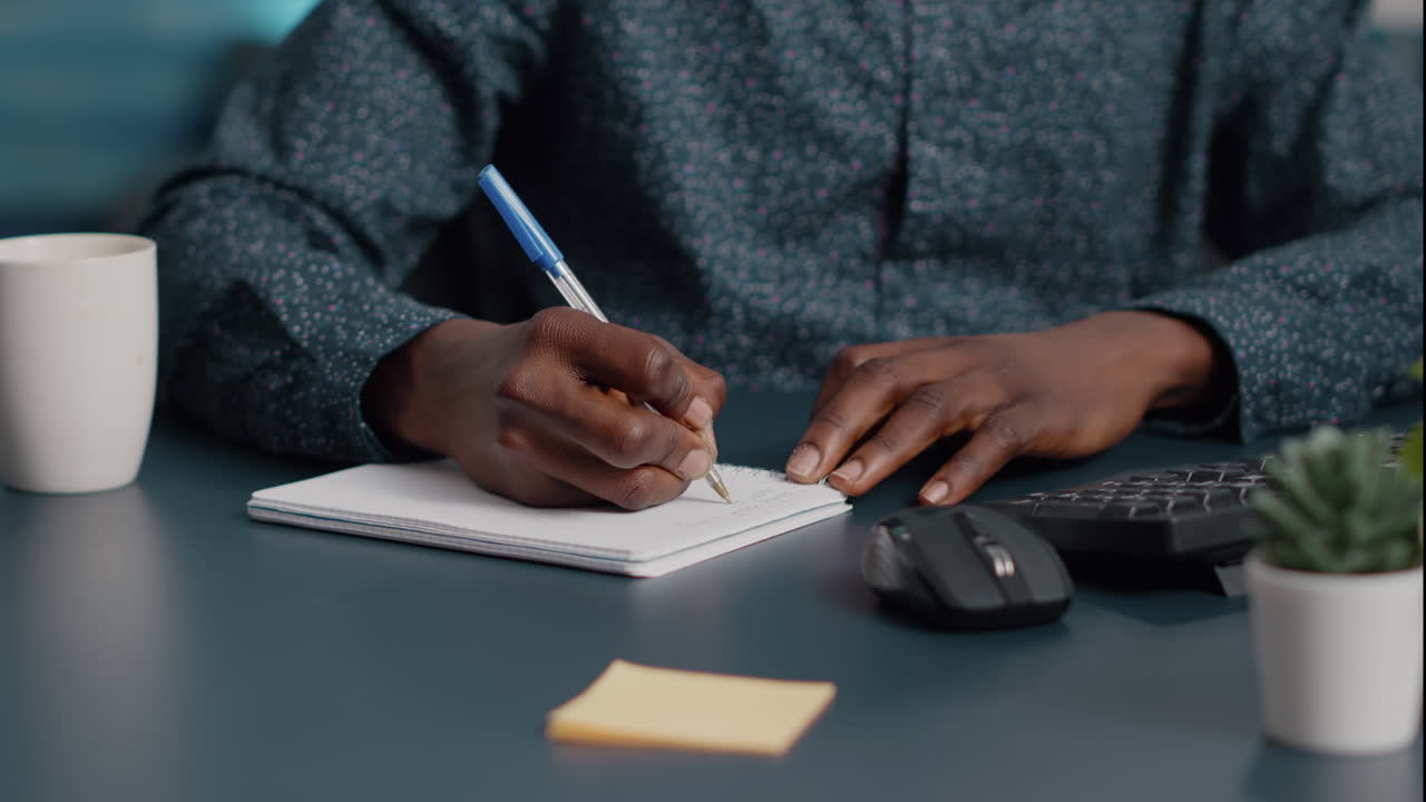 Closeup african american black man hands taking notes on notepad using a pen