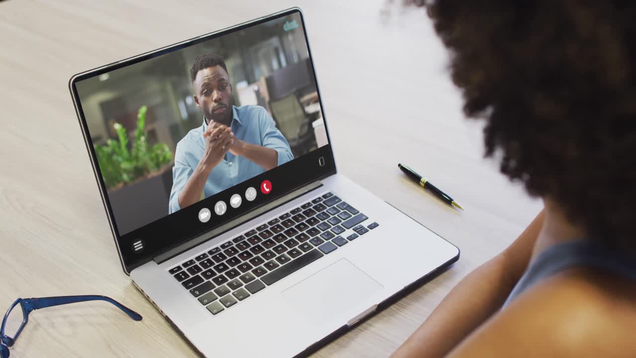 African american woman using laptop for video call, with business colleague on screen