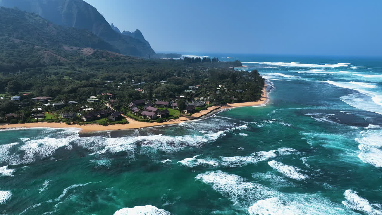 Drone flying backwards over waves in front of the Ke'e beach in Kauai, Hawaii