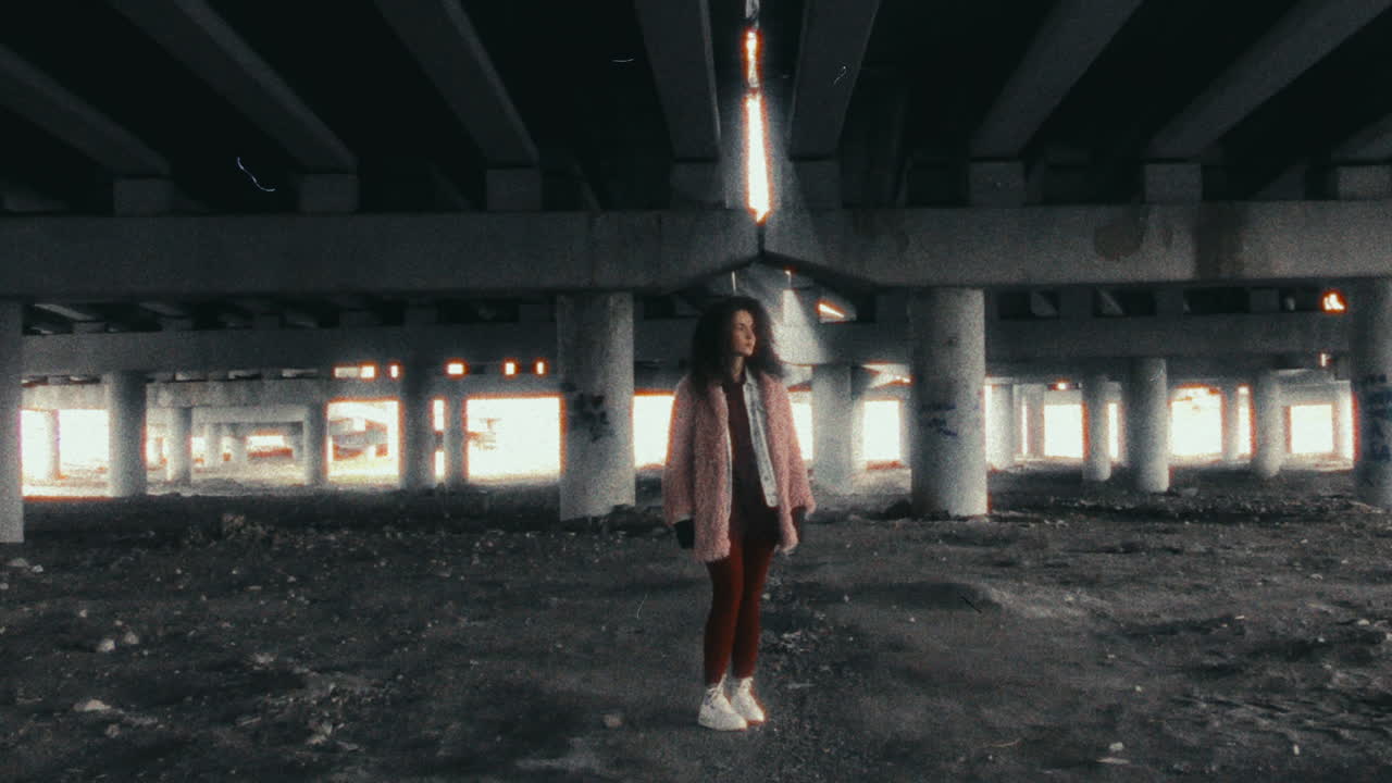 Portrait of Young Woman Standing Alone under Massive Concrete Overpass